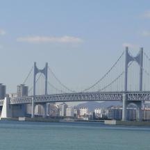 a bridge over the water with a city in the background