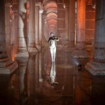 a woman is standing in a room with columns