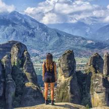 a woman standing on top of a rock formation