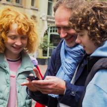 a group of people looking at a cell phone