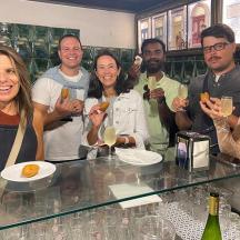 a group of people sitting at a bar drinking wine
