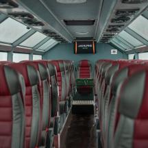 an empty bus with red seats on a bus