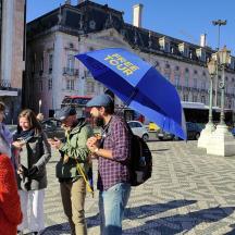 a group of people walking down a street with an umbrella