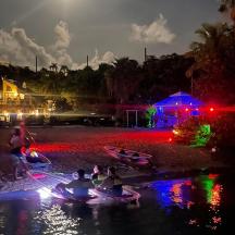 a group of people in boats on the water at night