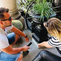 en mann og en kvinne som sitter på en benk og ser på en mobiltelefon