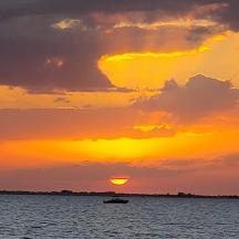 a boat in the water with a sunset