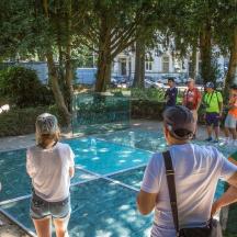 a group of people standing around a swimming pool