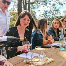 a group of people sitting at a table drinking wine