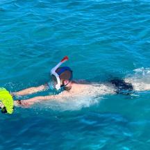 ein Mann, der mit einem Taucher im Wasser schwimmt
