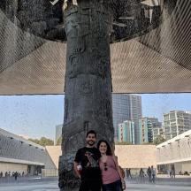 a man and woman standing in front of a tree