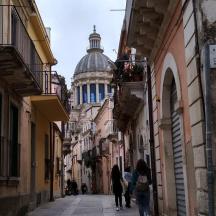 a group of people walking down a street with a building