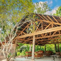 ein Holzpavillon mit Tischen und Stühlen darunter