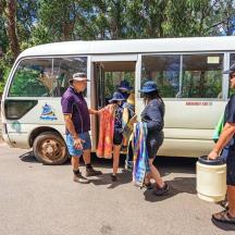 a group of people standing outside of a bus