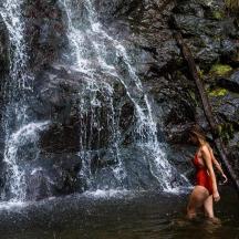 eine Frau steht vor einem Wasserfall