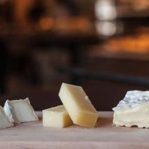 four pieces of cheese on a cutting board