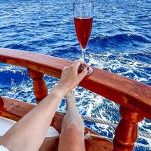 eine Person, die auf einem Boot ein Glas Wein hält