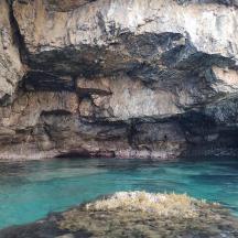 una piscina di acqua blu accanto a una scogliera rocciosa