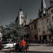a group of people on a city street with a clock tower