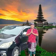 a man standing next to a car in front of a pagoda