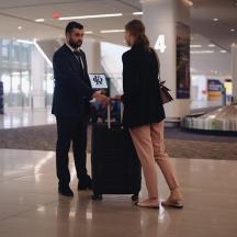 a man and woman shaking hands in an airport