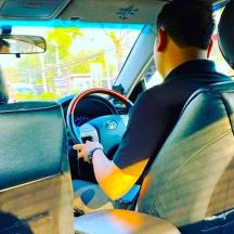 vyras, vairuojantis automobilį su banglente ant prietaisų skydelio