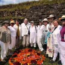 a group of people standing next to a pile of flowers