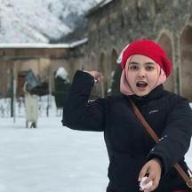a young child is standing in the snow