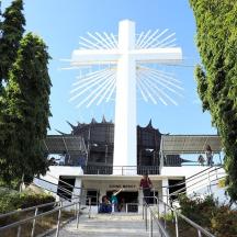 a large white cross in front of a building