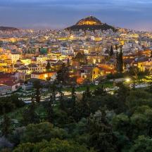 una ciutat de nit amb una muntanya al fons