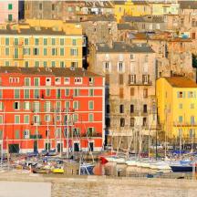 a group of buildings with boats in a harbor