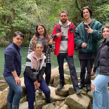 eine Gruppe von Menschen, die auf Felsen in der Nähe eines Flusses stehen