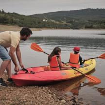 ein Mann und zwei Personen in einem Kajak auf einem See