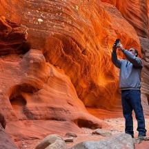 ein Mann, der in einer Schlucht steht und ein Foto macht