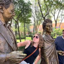 Un grupo de personas de pie junto a una estatua