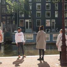 a group of people standing on a sidewalk near a river