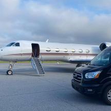 a car parked next to a plane on a runway