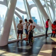 a group of people standing in a building looking at the city