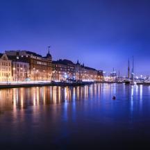 a city at night with boats in the water
