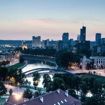 a city skyline at night with a river and a bridge