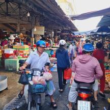 a group of people riding motorcycles in a market