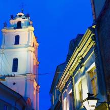 a tall white building with a clock tower at night