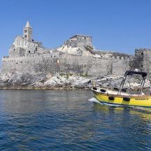 a yellow boat in the water in front of a castle