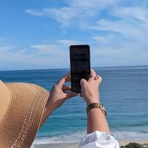 una persona che scatta una foto dell'oceano con un cellulare