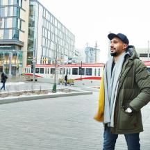 a man standing on a street in front of a train