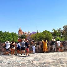 a group of people looking over a stone wall