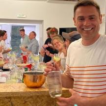 ein Mann, der an einem Tisch sitzt und ein Glas hält