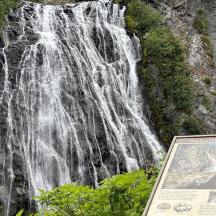 a waterfall with a sign in front of it