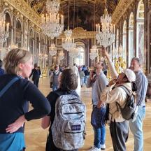 a group of people standing in a large room with chandeliers
