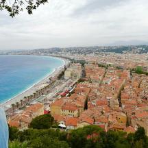 a woman looking down at a city and the ocean