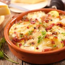 una ciotola di cibo con pancetta e formaggio su un tavolo